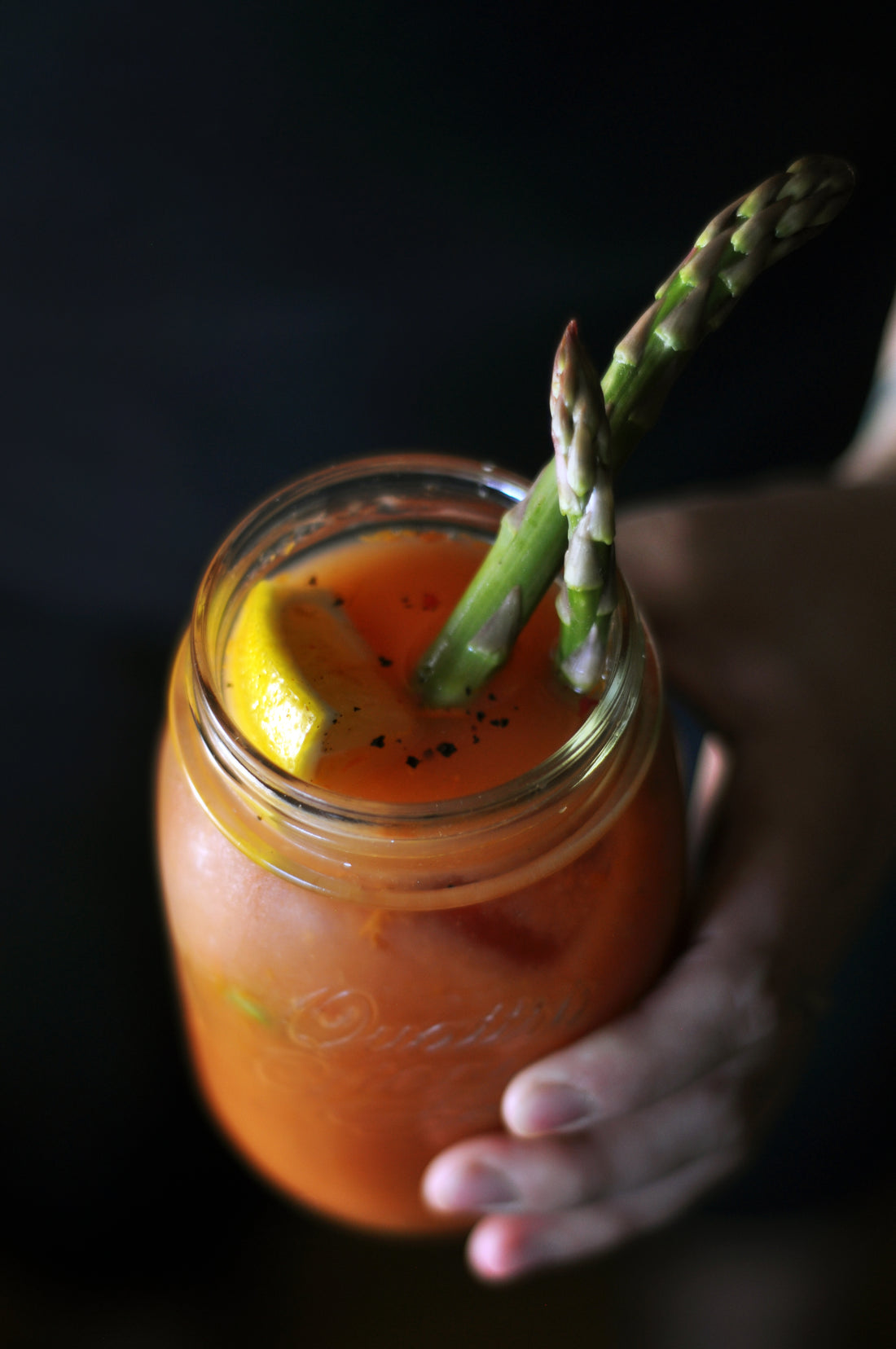 Hany's Harvest Wild Mary Recipe served in Mason jar, garnished with Asparagus and lemon.